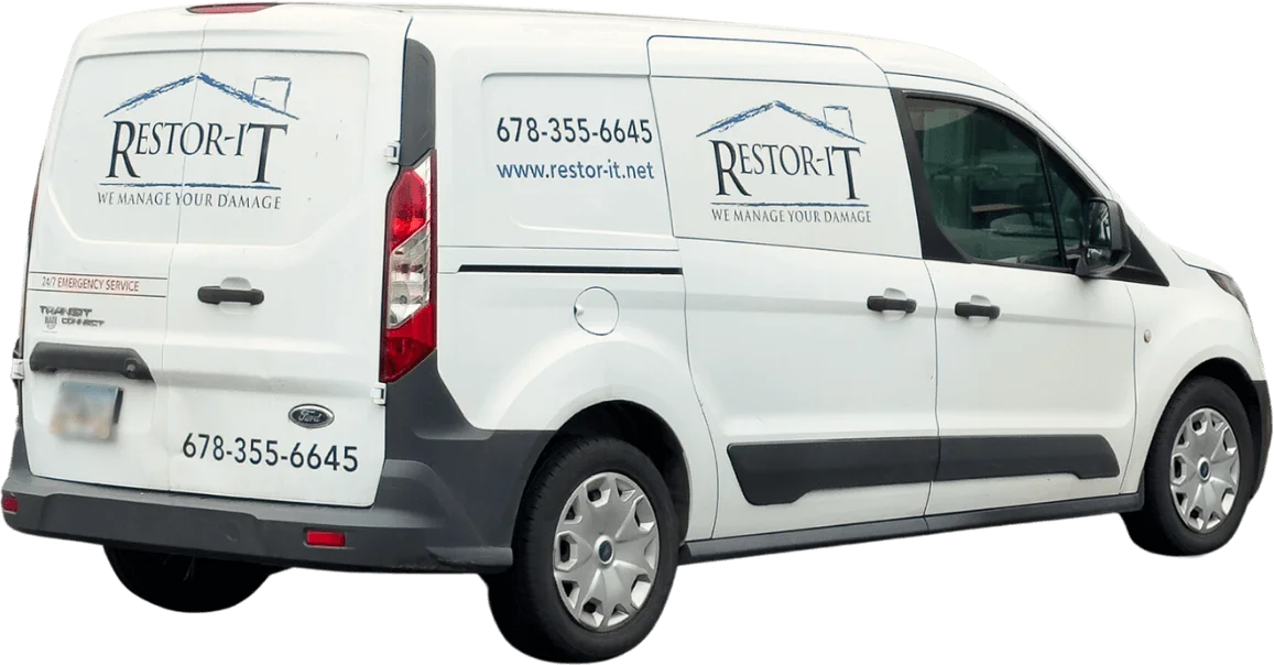 White van with "Restor-It" logo and contact information, including phone number and website URL, on the side and rear. The slogan reads, "We Manage Your Damage." Our services are designed to restore your property efficiently and effectively.
