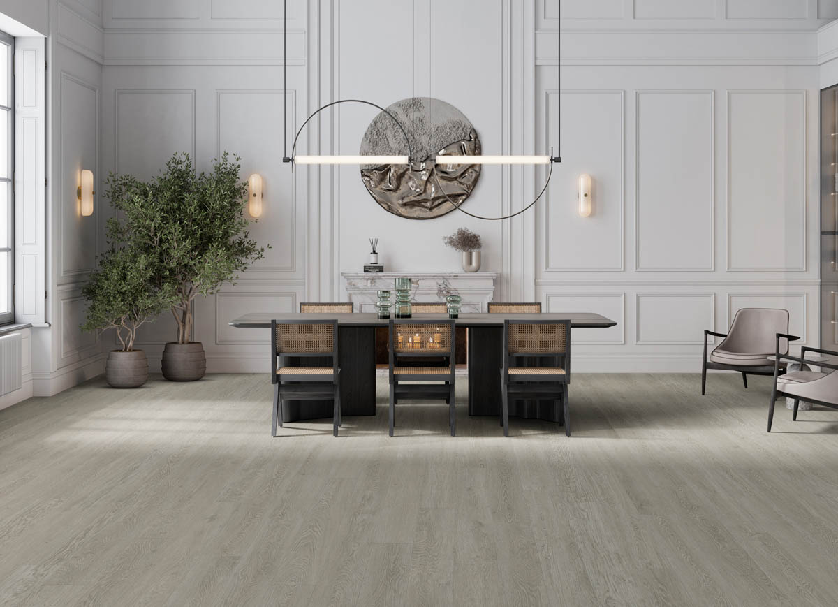 Flooring Installation 5 A modern dining room with a large table, four chairs, a minimalist chandelier, potted plants, and a round wall decor piece above a fireplace. The room features light wood flooring and panelled walls.