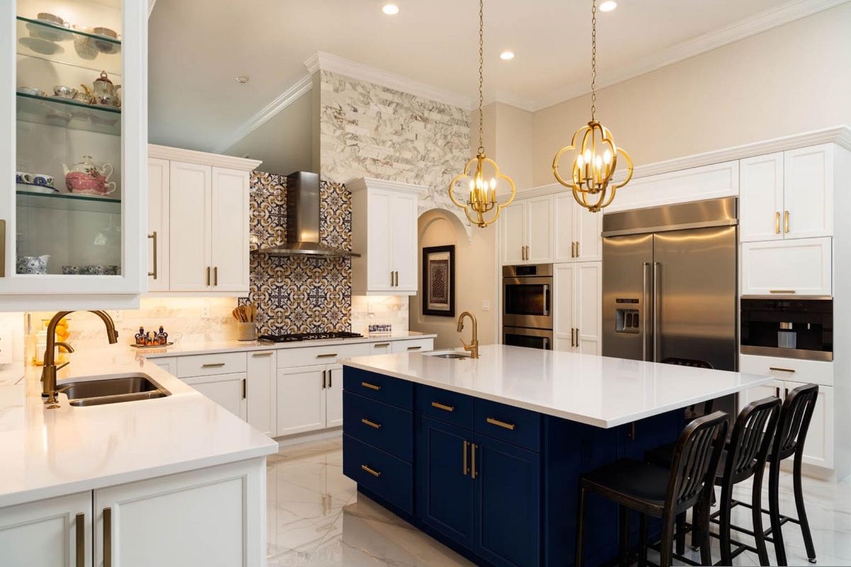 Kitchen Remodeling In Atlanta: How To Transform Your Space 9 Modern kitchen remodeling with white cabinets, blue island, stainless steel appliances, gold fixtures, pendant lights, and a patterned backsplash.
