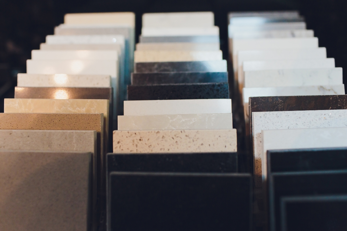 Tile Flooring Installation: Why It’s A Great Choice For Atlanta Homes 15 Rows of rectangular countertop or tile samples in various colors and patterns displayed upright in a showroom, perfect for planning your next tile flooring installation.
