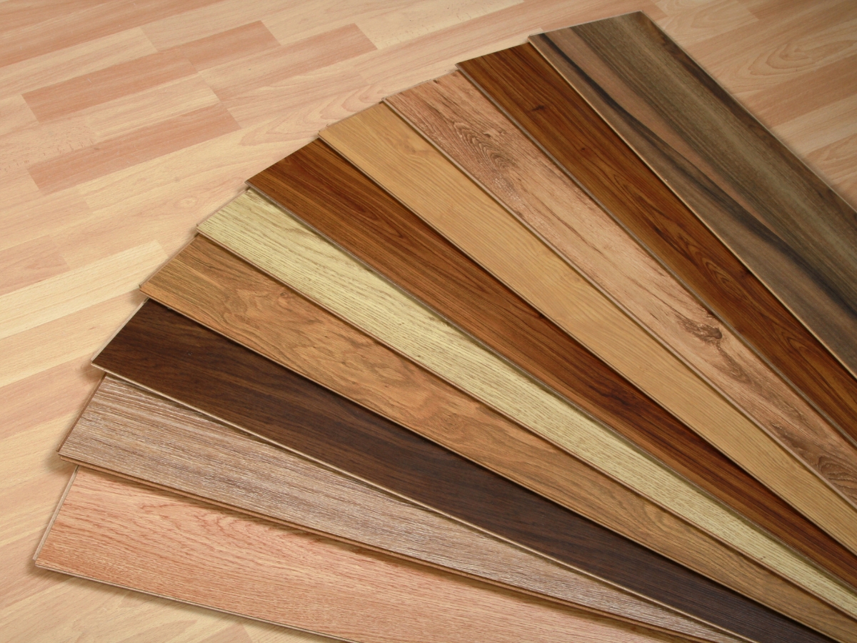Best Flooring For High-Traffic Areas: A Homeowner’s Guide To Durability And Style 8 A fan display of wood flooring samples in various shades and grain patterns showcases options for those seeking the best flooring for high-traffic areas, all set against a light wood floor background.