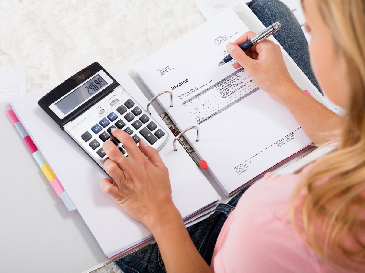 How To Prevent Water Damage In Your Home Before It’s Too Late 12 A person calculating an invoice to ensure timely payments and prevent water damage from unpaid utility bills.