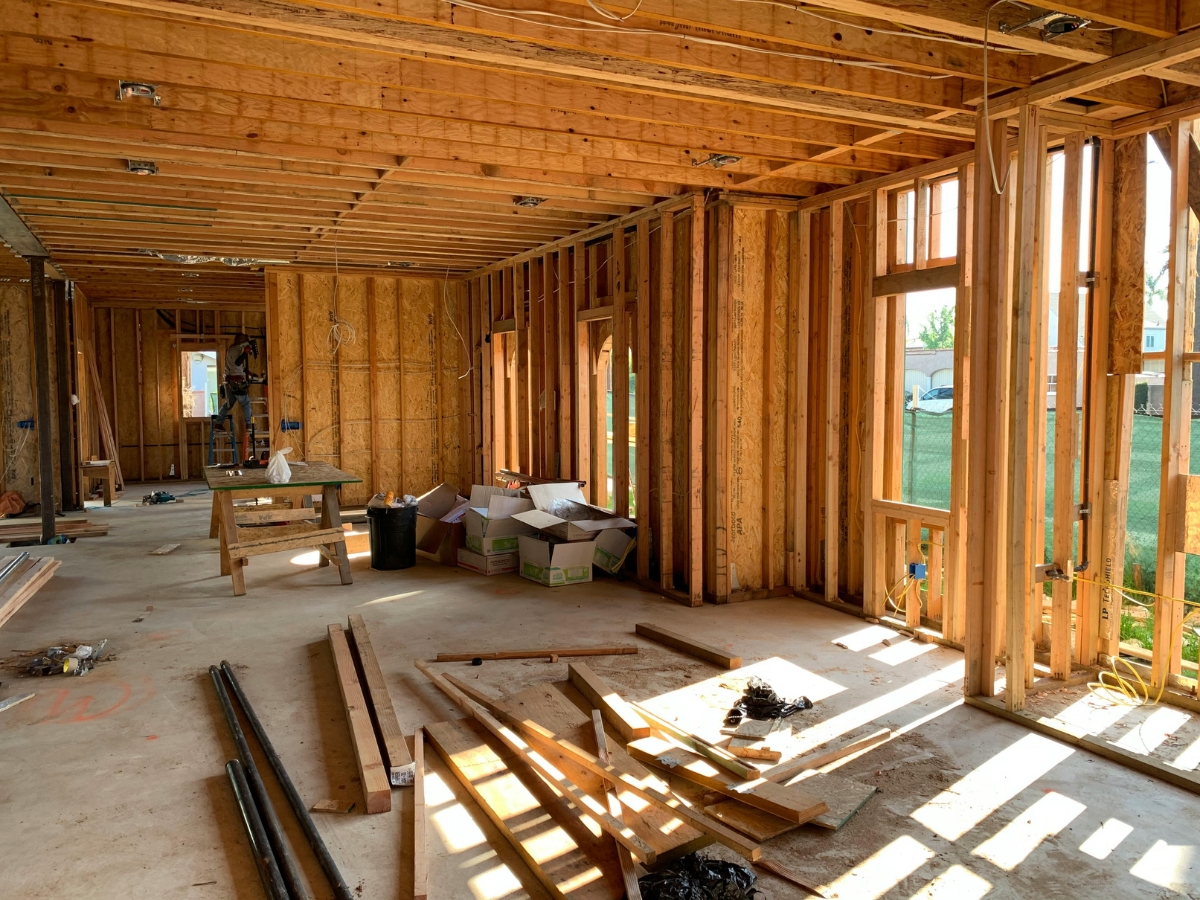 Atlanta Home Renovation Experts: What To Expect From Your Remodel 4 Interior of an Atlanta Home Renovation project, showcasing exposed wooden framing, scattered building materials, and sunlight streaming through open window spaces.